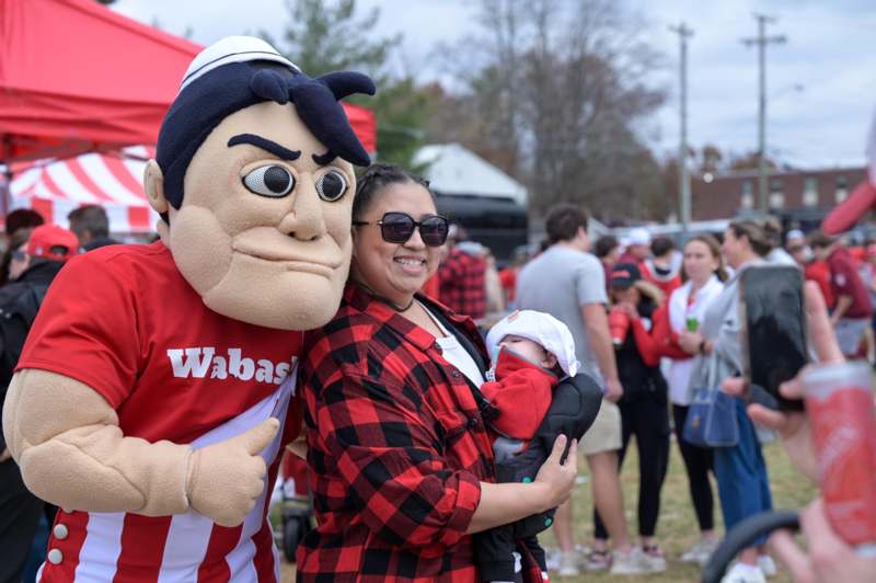 a woman holding a baby in a person's garment