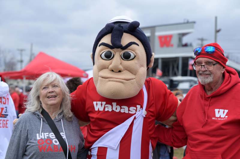 a man in a mascot garment with a woman in a red shirt