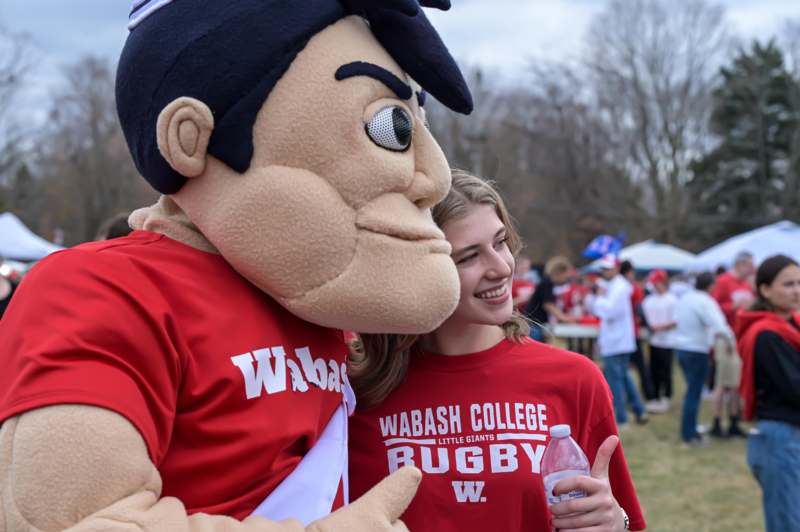 a woman in red shirt with a person in a mascot garment