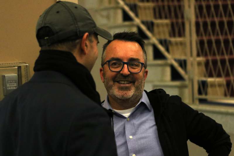 a man in a cap talking to another man