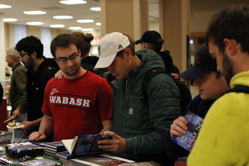 a group of people looking at books
