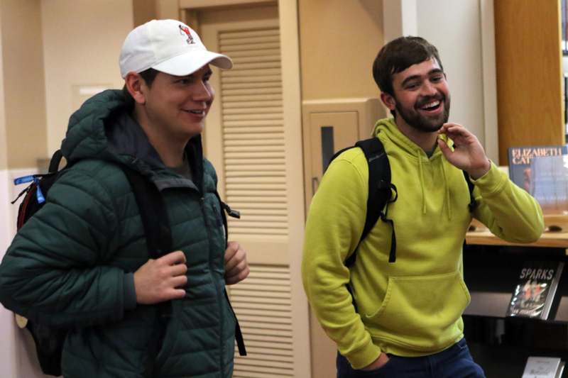two men smiling and walking in a room