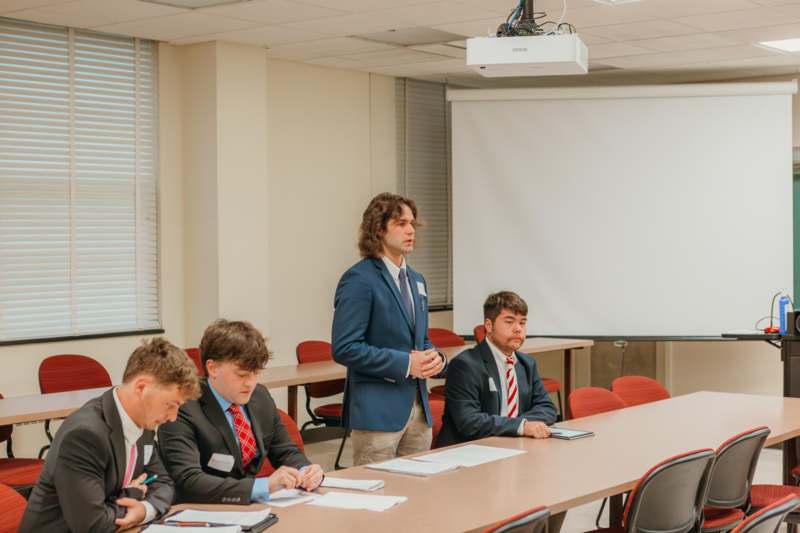 a group of men in suits in a meeting