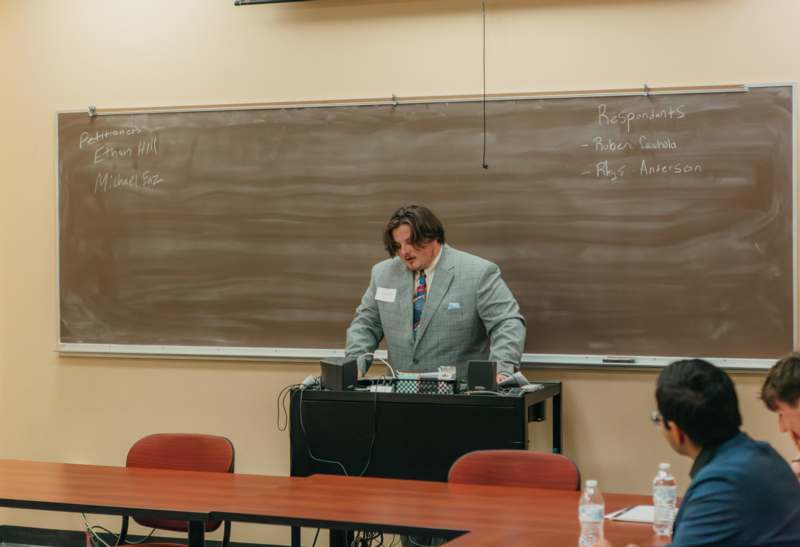 a man standing in front of a blackboard