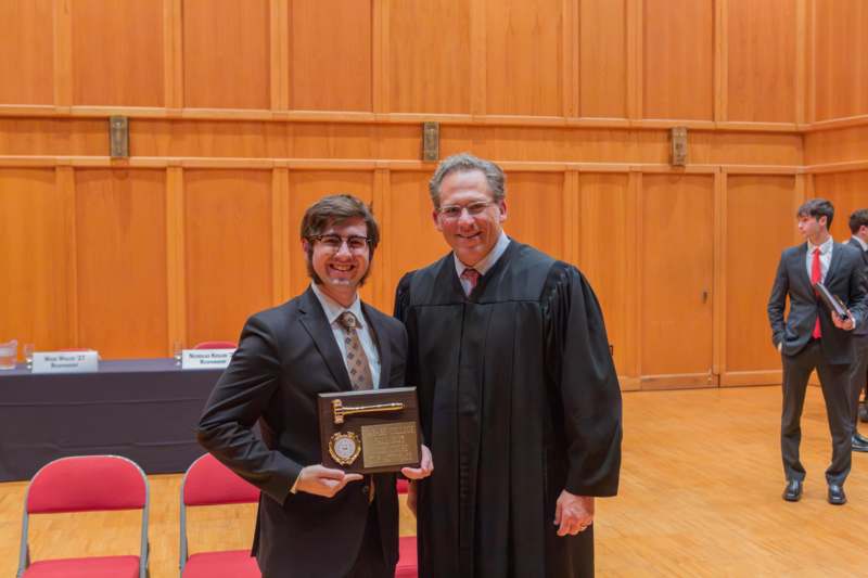 a man in a robe holding a plaque