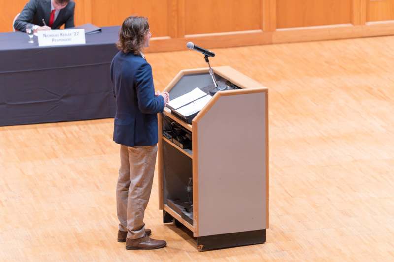 a man standing at a podium with a microphone