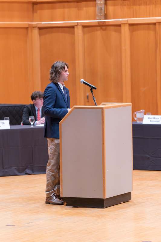 a man standing at a podium with a microphone