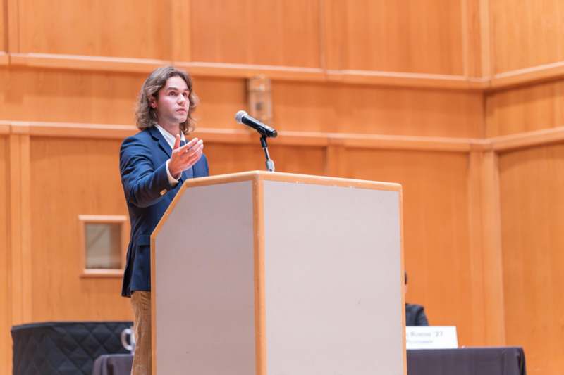 a man standing at a podium with a microphone