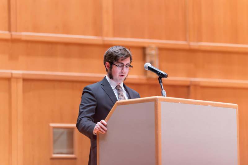 a man standing at a podium with a microphone