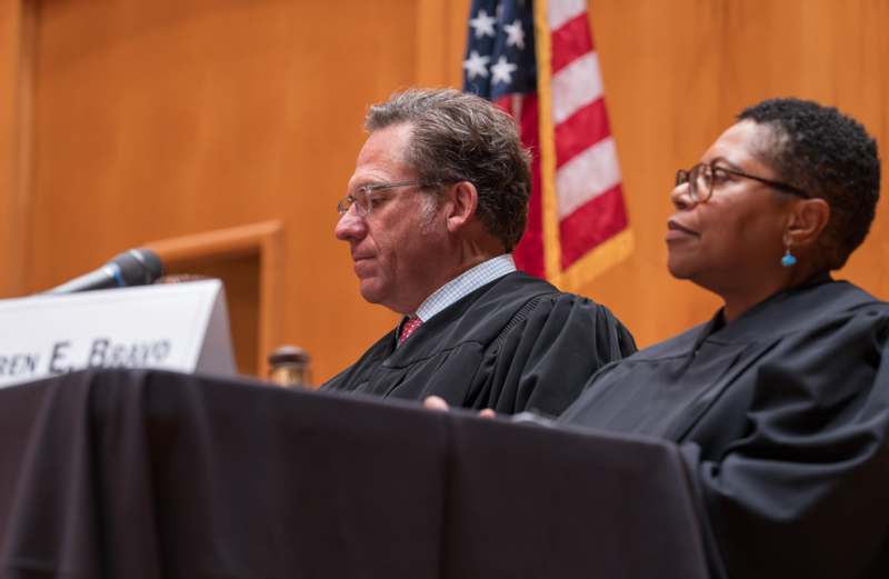 a man and woman in black robes sitting at a podium