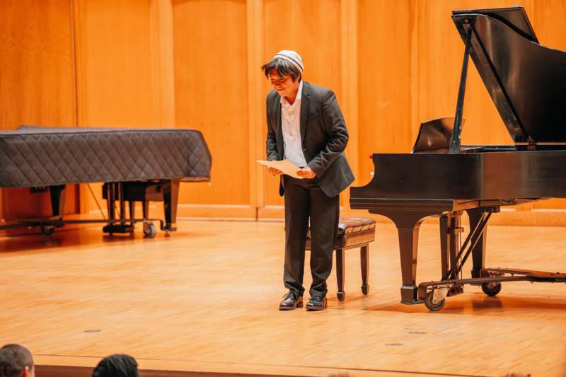 a man standing in front of a piano