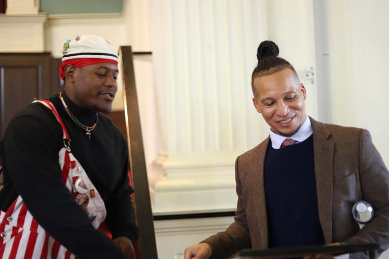 a man standing next to another man