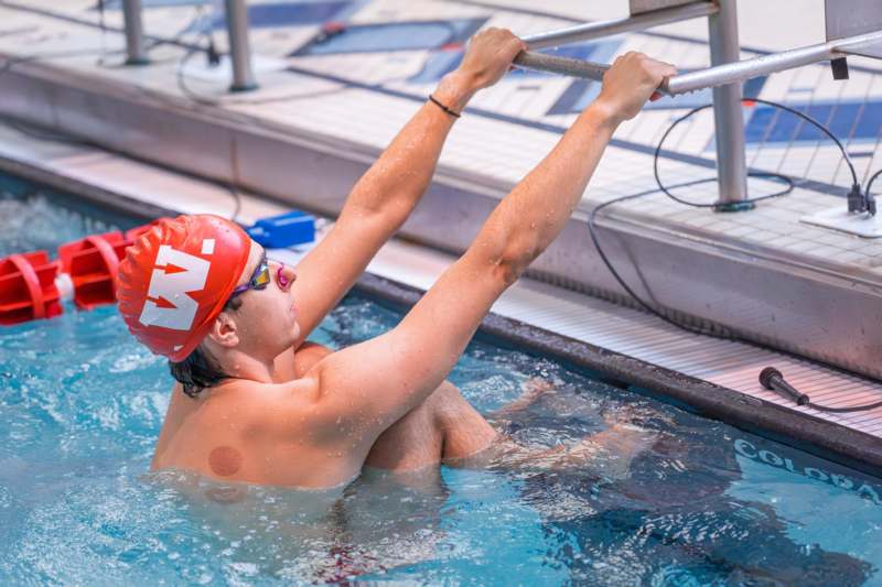 a man in a swimming pool holding a bar