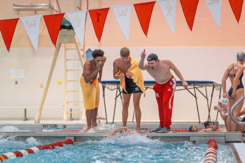 a group of men standing on a pool edge
