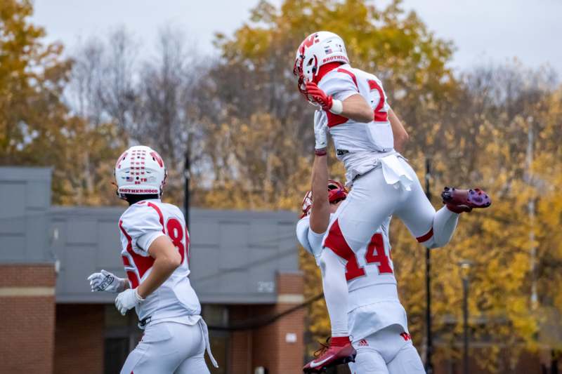a group of football players in uniform jumping in the air