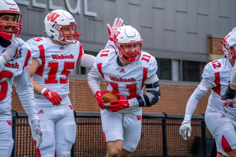 a group of football players running with a football