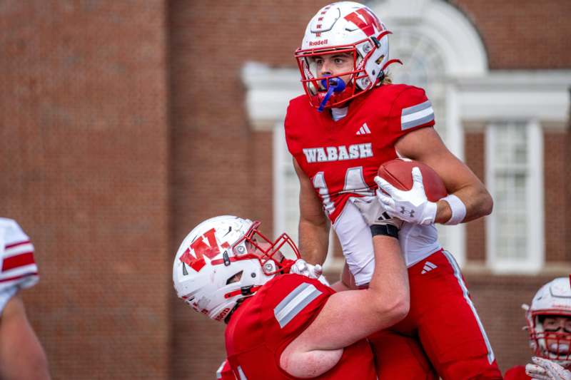 a football player carrying another football