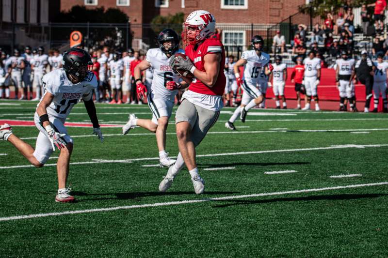 a football player running with a football in the air