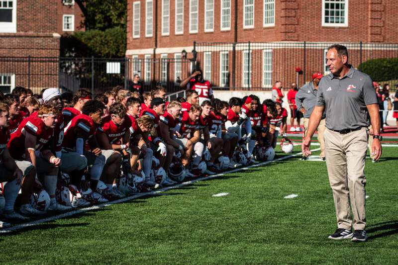 a football coach standing in a line with a group of people