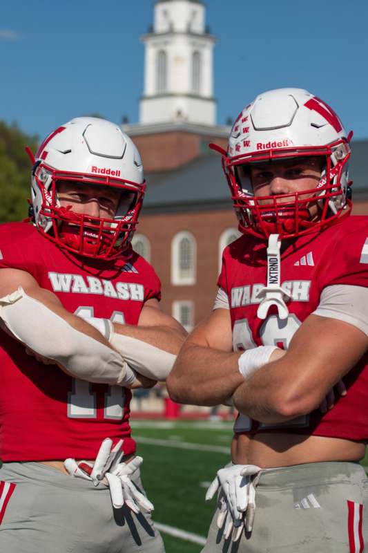 two football players wearing helmets and standing on a field