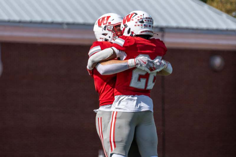 two football players hugging on a field