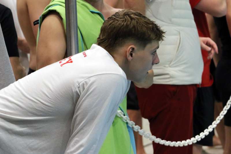 a man leaning against a pole