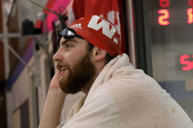 a man wearing a swimming cap and sunglasses