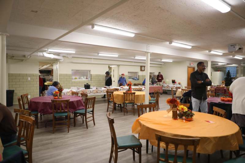 Community Thanksgiving Dinner 2025 - a group of people in a room with tables and chairs