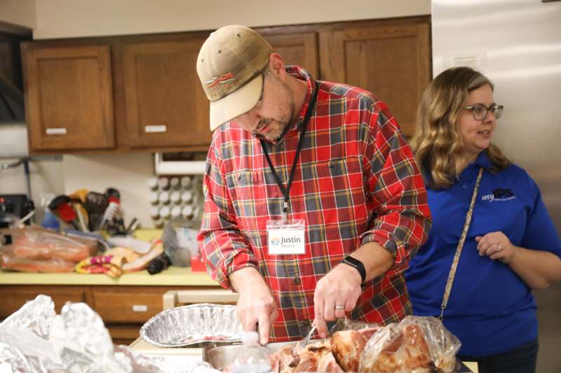 a man cutting meat in a kitchen
