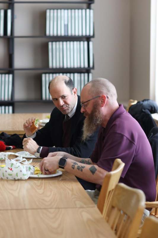 a group of men sitting at a table eating food