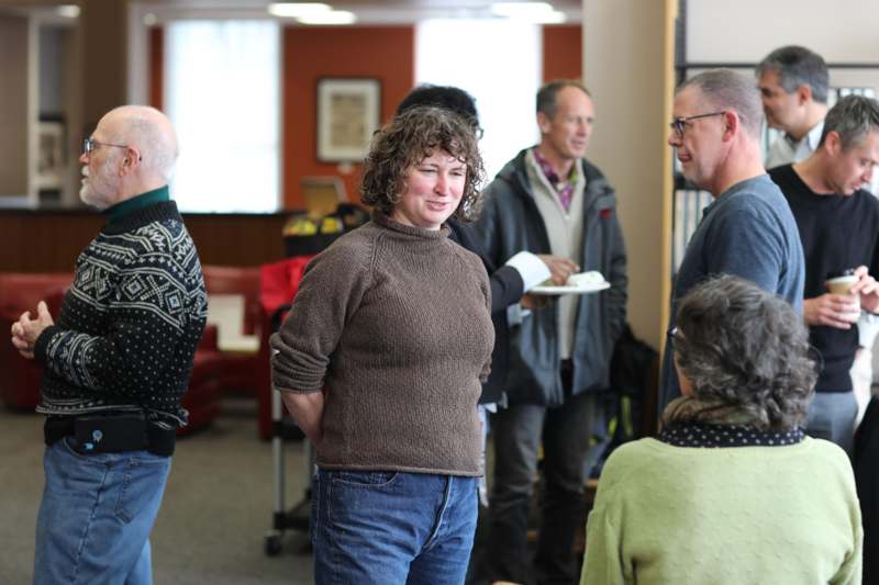 a woman standing in a room with people around her