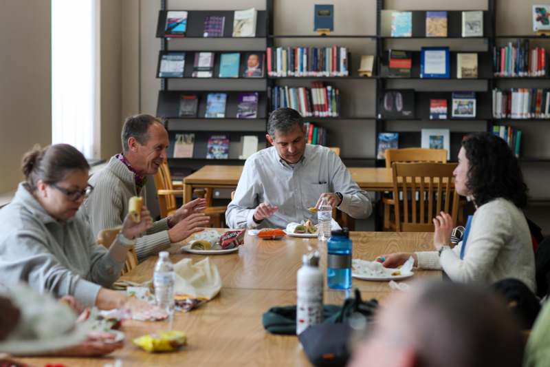 a group of people sitting at a table eating food