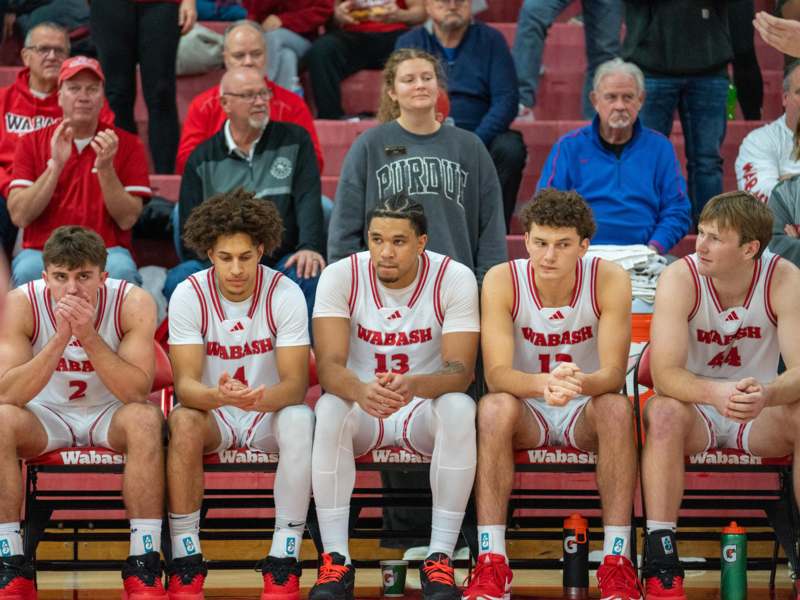 Basketball vs Depauw - a group of men sitting on benches