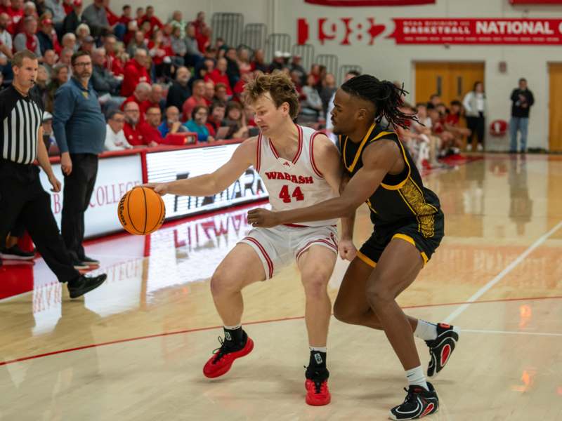 a basketball player in uniform dribbling a basketball