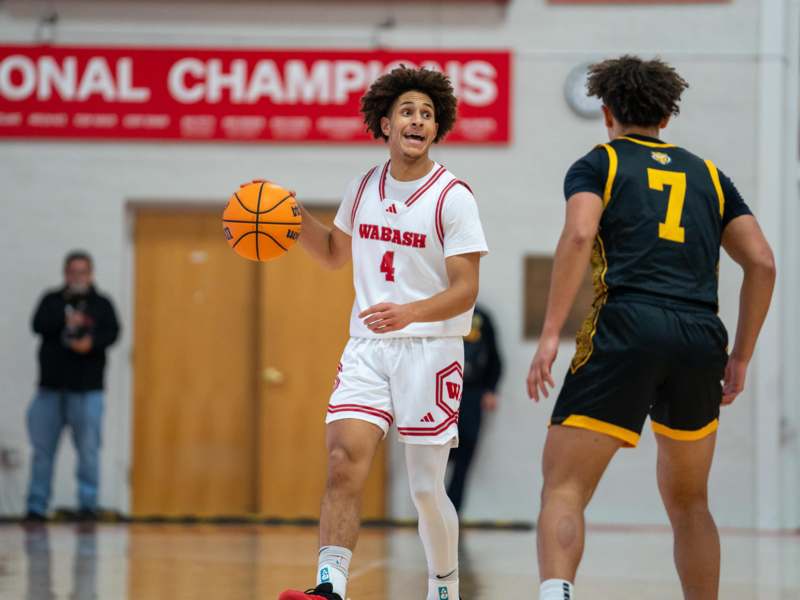 a man in a white uniform holding a basketball