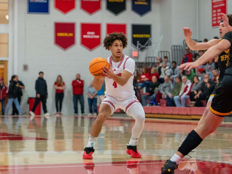 a man in a white uniform dribbling a basketball