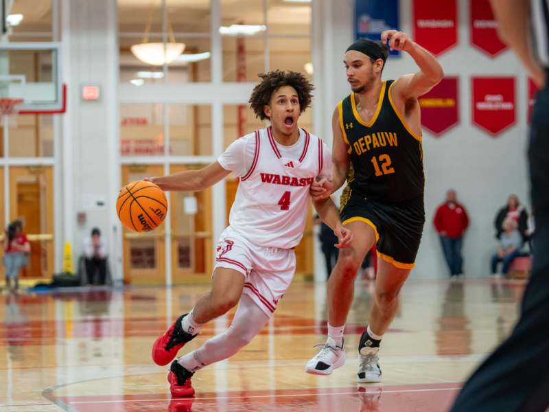 a man running with a basketball in front of another man
