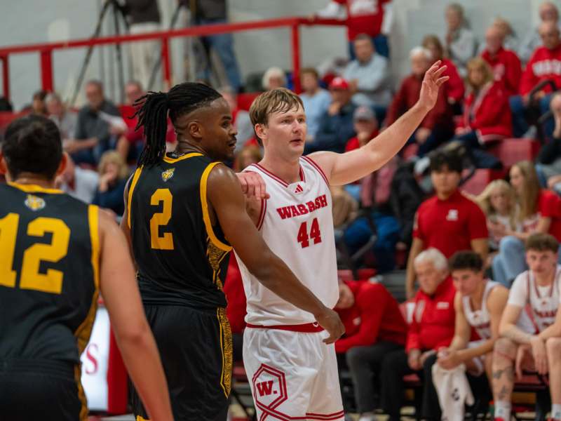 a basketball player in a uniform with his arm up