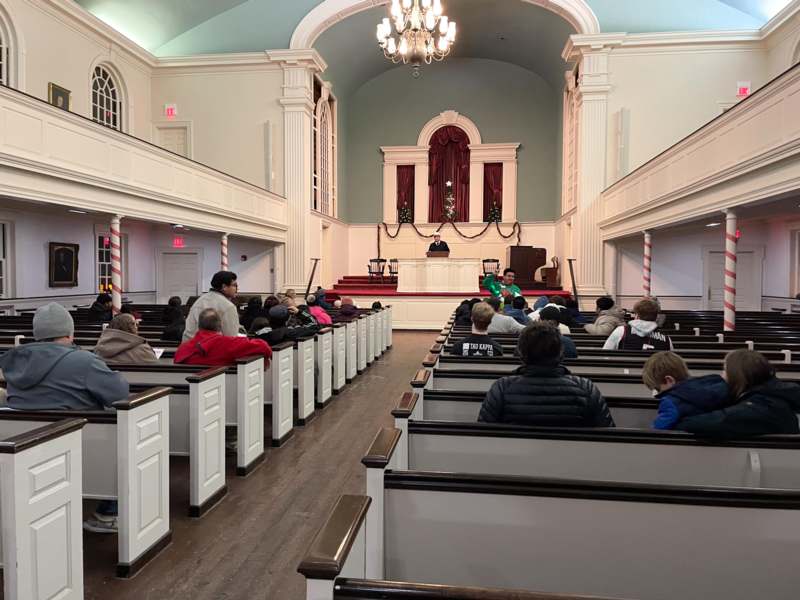 a group of people sitting in pews in a church