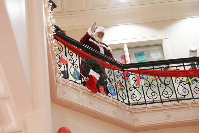 a man in a garment waving from a balcony