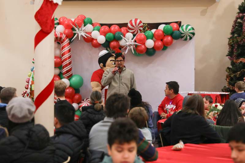 a man speaking into a microphone in front of a group of people