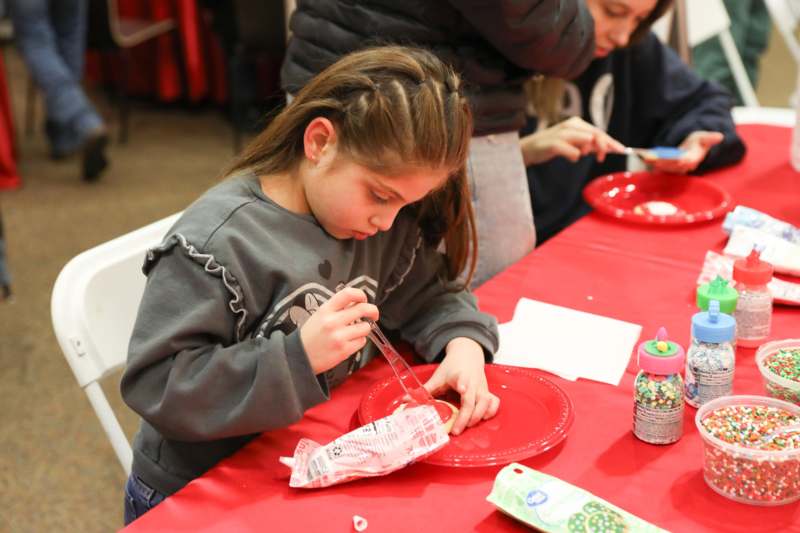 a girl painting a cookie on a red plate