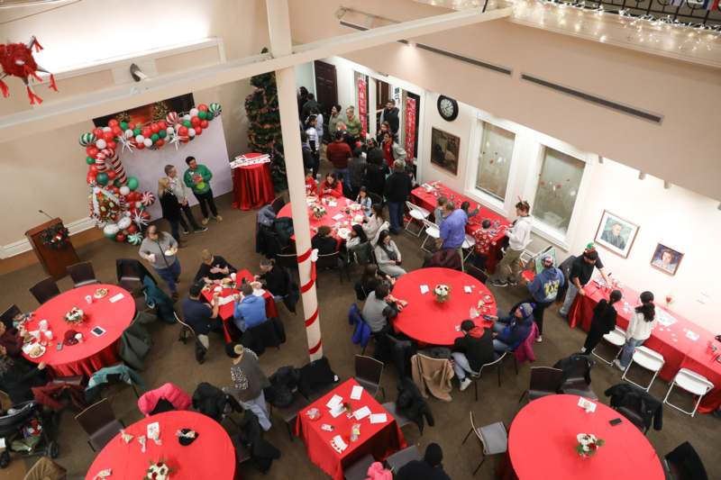 a group of people in a room with tables and red tables