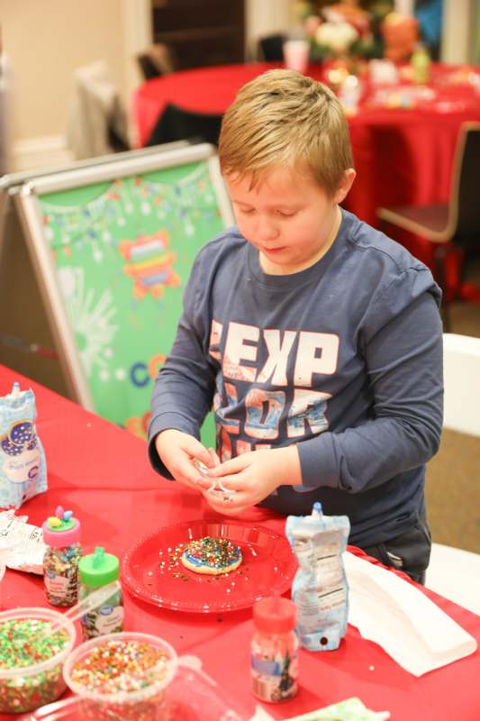 a boy decorating a cookie