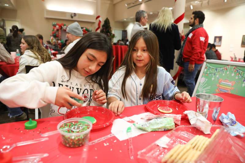 a group of girls at a table with red plates and red tablecloths