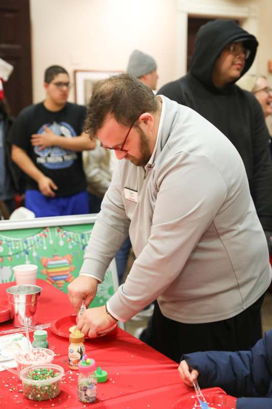 a man standing at a table with a cupcake