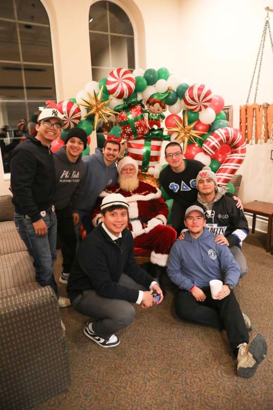a group of men posing for a photo with santa claus