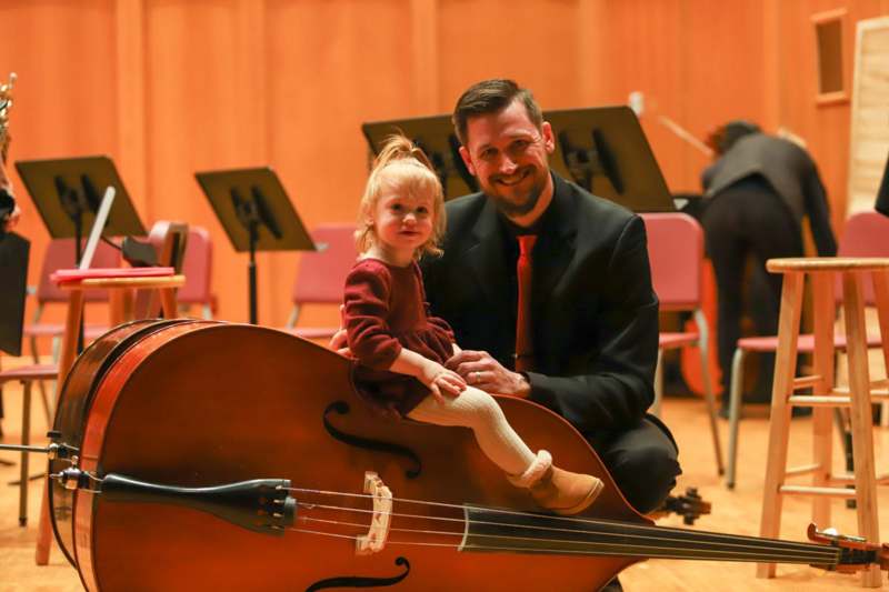 a man and a child posing with a cello