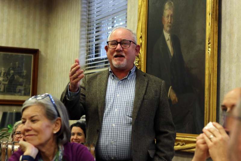 a man in a suit standing in front of a group of people
