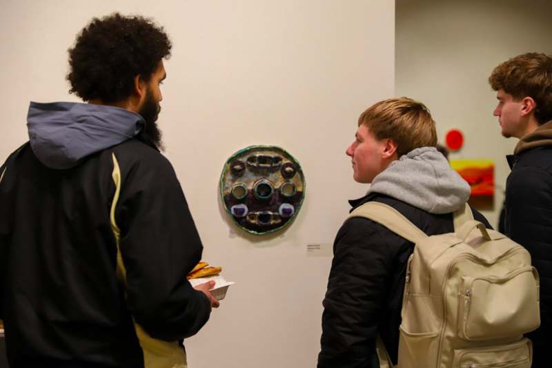 a group of men looking at a piece of art